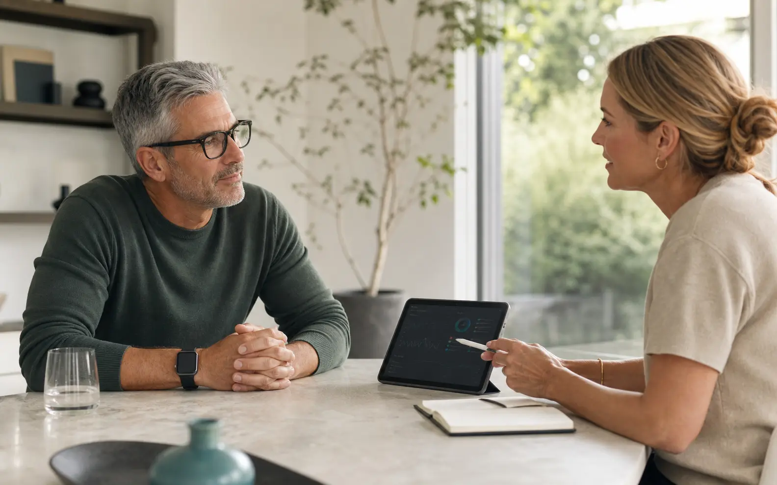 A mature client discussing long-term health data and their UltraPerson personalized supplement plan with a professional in a bright consultation.